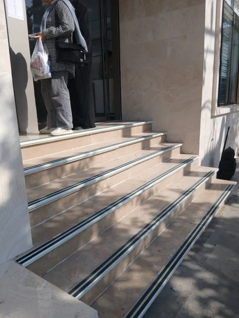 نصب ترمز پله آلومینیومی با نوار ضد لغزش در لبه پله برای جلوگیری از سقوط و لغزش مطابق با مقررات ملی ساختمان نصب ترمز پله آلومینیومی با نوار ضد لغزش در لبه پله برای جلوگیری از سقوط و لغزش مطابق با مقررات ملی ساختمان